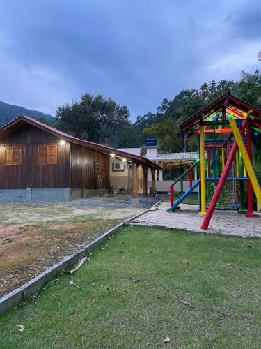 ein Spielplatz vor einem Haus mit einem Gebäude in der Unterkunft Sítio Feltz in Canelinha