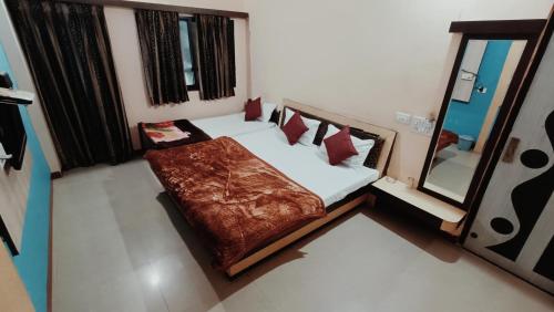 a small bedroom with a bed and a mirror at Hotel chaitanya in Maheshwar