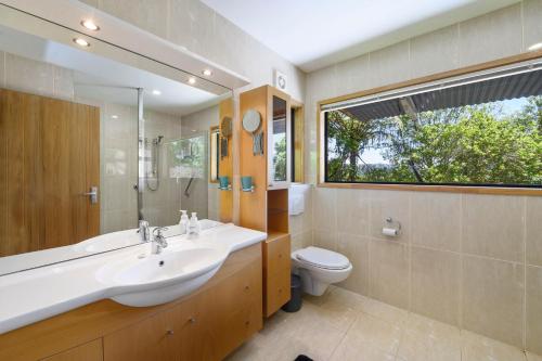 a bathroom with a sink and a toilet and a window at Tironui Lake Tarawera in Lake Tarawera
