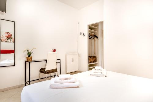 um quarto branco com três toalhas numa mesa em Petite Maison 19 em Roma