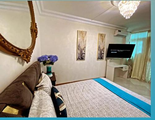 a living room with a couch and a flat screen tv at HABITACION CON BAÑO COMPARTIDO in Guayaquil