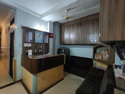 a kitchen with a counter and wooden cabinets at Hotel chaitanya in Maheshwar