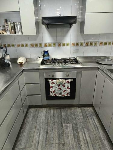 a kitchen with a stove with a towel on it at casa en el norte de la ciudad, a 5 minutos del portal norte in Bogotá