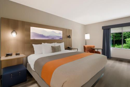 a hotel room with a large bed and a window at Graystone Lodge, an Ascend Collection Hotel in Boone