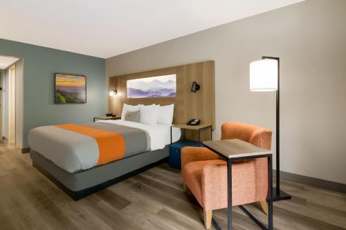 a hotel room with a bed and a chair at Graystone Lodge, an Ascend Collection Hotel in Boone