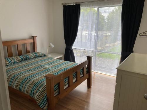 a bedroom with a bed and a large window at Bay views on Laurie in Encounter Bay
