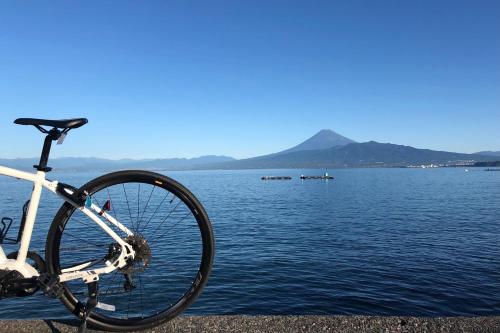 a bike parked next to a body of water at Kona Stay Bicycle Resort in Izunokuni