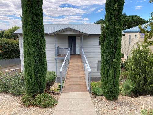 a house with a staircase leading to a house between two trees at Bay views on Laurie in Encounter Bay