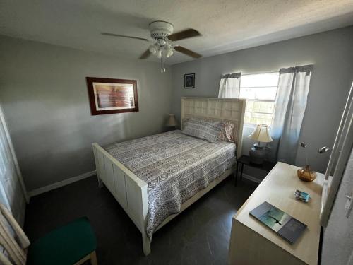 a small bedroom with a bed and a table at Surfside Suites in Cocoa Beach