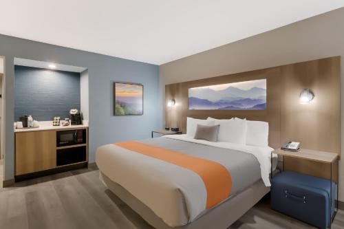 a hotel room with a large bed and a bathroom at Graystone Lodge, an Ascend Collection Hotel in Boone