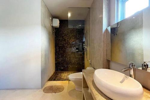 uma casa de banho com um lavatório, um WC e um chuveiro em Zenith villa Pererenan em Munggu
