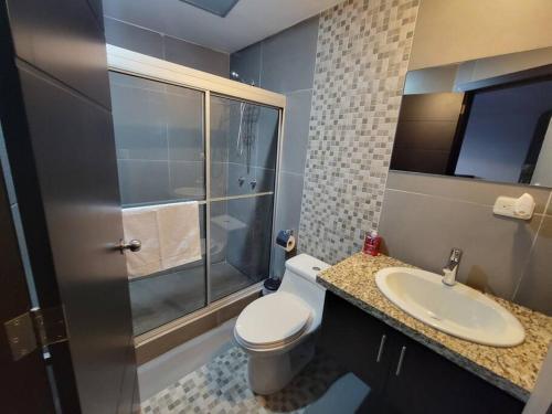 uma casa de banho com um WC, um lavatório e um chuveiro em Departamento Duplex con Terraza em Cuenca