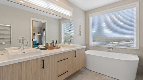 a bathroom with two sinks and a large window at Boat House in Metung
