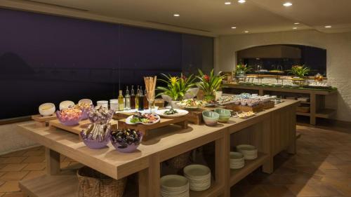 a long table with food and drinks on it at Hotel Nishinagato Resort in Takibe