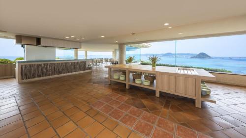 a large kitchen with a view of the ocean at Hotel Nishinagato Resort in Takibe