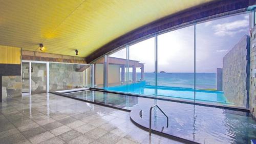 una piscina en un edificio con vistas al océano en Hotel Nishinagato Resort en Takibe
