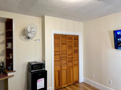 a room with a door with a fan and a microwave at Traveler’s Den in Medford in Medford