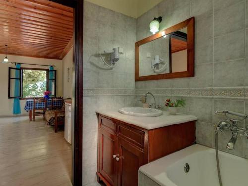 a bathroom with a sink and a tub and a mirror at Group Accomodation, Heliopetra Studios And Houses in Douliana