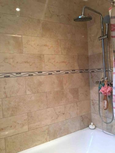 a shower in a bathroom with a bath tub at Nice comfy house in London