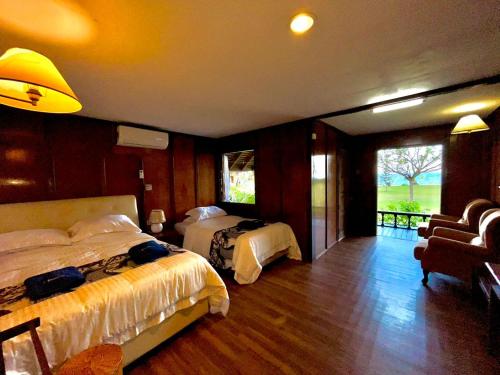 a hotel room with two beds and a balcony at ALUN ALUN ISLAND RESORT in Kampong Atap Zing