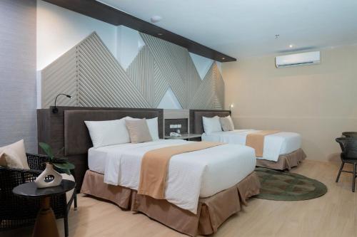 a hotel room with two beds and a large window at Adelina Hotel and Suites in Mati