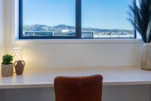 a chair sitting in front of a window at Central Charm 2 bed 2 bath w/ sunny Balcony in Christchurch