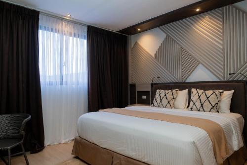 Una cama o camas en una habitación de Adelina Hotel and Suites
