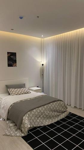 a bedroom with a large bed and white curtains at Luxury Apartment in Riyadh