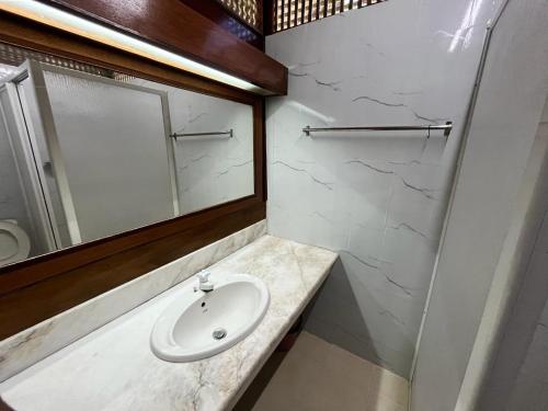 a bathroom with a sink and a mirror at ALUN ALUN ISLAND RESORT in Kampong Atap Zing