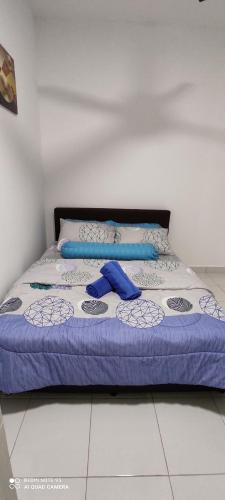 AYMAR Homestay, Residensi Lily, Nilai في نيلاي: سرير في غرفة عليها غرض ازرق