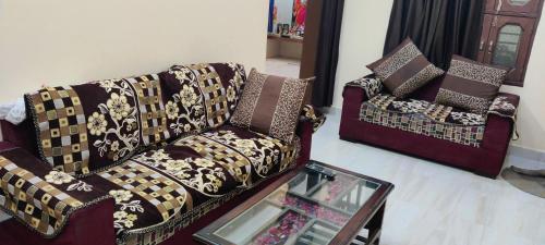 ein Wohnzimmer mit 2 Sofas und einem Tisch in der Unterkunft Brijlok Dham homestay in Mathura