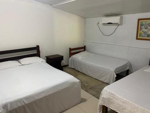 a bedroom with two beds and a air conditioner at Chacara Maluco Beleza 2 in Gravatá