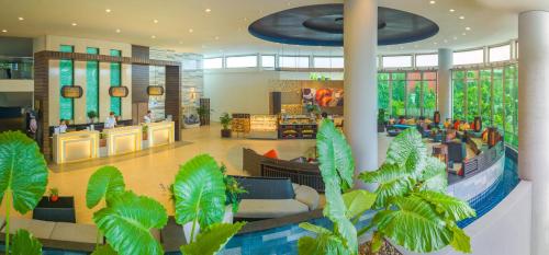 a lobby of a hotel with plants in it at Deevana Plaza Phuket - SHA Extra Plus in Patong Beach