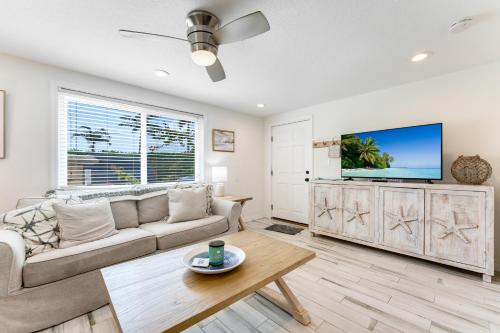 a living room with a couch and a tv at Tides Inn on the Bay Vacation Homes in Bradenton Beach