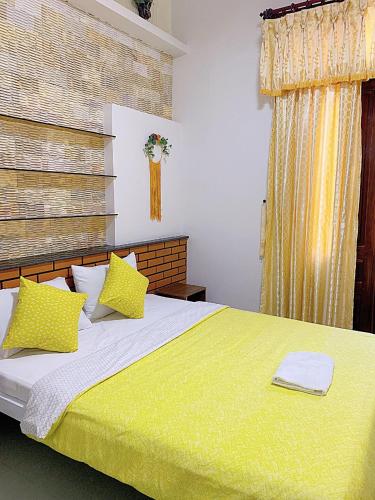 a bedroom with a green bed with yellow pillows at Letters Bà Triệu in Liên Trì (3)