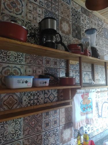 a kitchen with wooden shelves with pots and pans at Hospedaserra in Tiradentes