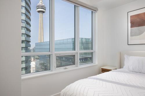 a bedroom with a large window with a view of the space needle at Lakefront Retreat: Designer Suite w/Stunning Views in Toronto