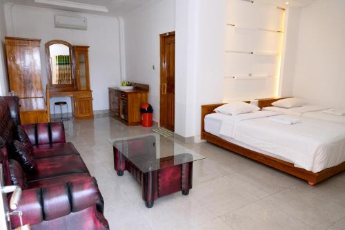 ラブハン・バジョにあるGreen Prundi Hotelのベッドルーム1室(ベッド1台、ソファ、テーブル付)