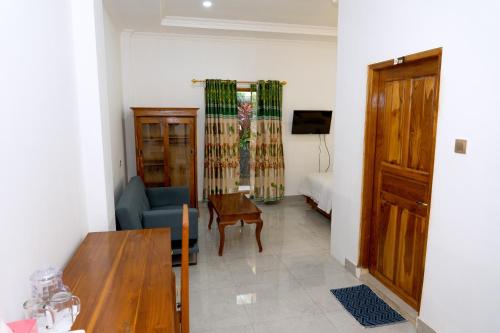 a living room with a couch and a table at Green Prundi Hotel in Labuan Bajo