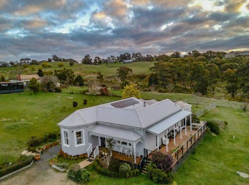 an aerial view of a large white house in a field at Dairy House- an idyllic country escape, Daylesford in Daylesford