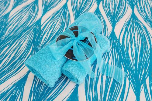 a blue towel with a blue bow on a table at H2O GuestHouse in Baleal