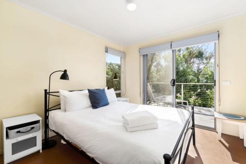 a bedroom with a bed and a large window at Altair in Wye River