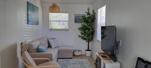 a living room with a couch and a tv at Conch Club Cottage in Head of Bay