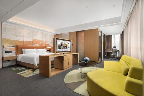 a hotel room with a bed and a couch at Hampton by Hilton Nanning Jiangnan in Nanning