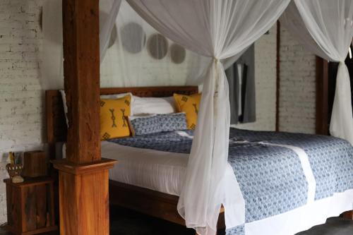 a bedroom with a bed with a canopy at Ubuntu Bali Eco Yoga Retreat - CANGGU in Canggu