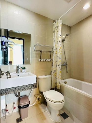 a bathroom with a toilet and a sink and a tub at One Manchester Place by Hiverooms in Punta Engaño