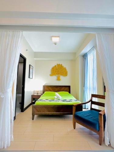 a bedroom with a bed and a chair and a window at One Manchester Place by Hiverooms in Punta Engaño