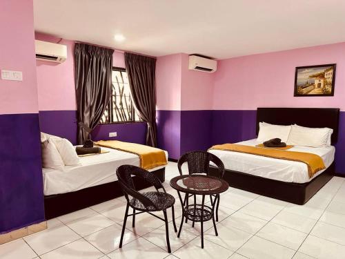 巴生的住宿－Smart Budget Hotel - Klang，酒店客房带两张床和一张桌子以及椅子。