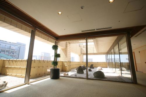 a large glass window in a building with people sitting on the ground at Hotel Port Plaza Chiba in Chiba