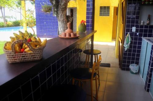 blat z koszem owoców i dwoma stołkami w obiekcie Casa do paiva w mieście Cabo de Santo Agostinho